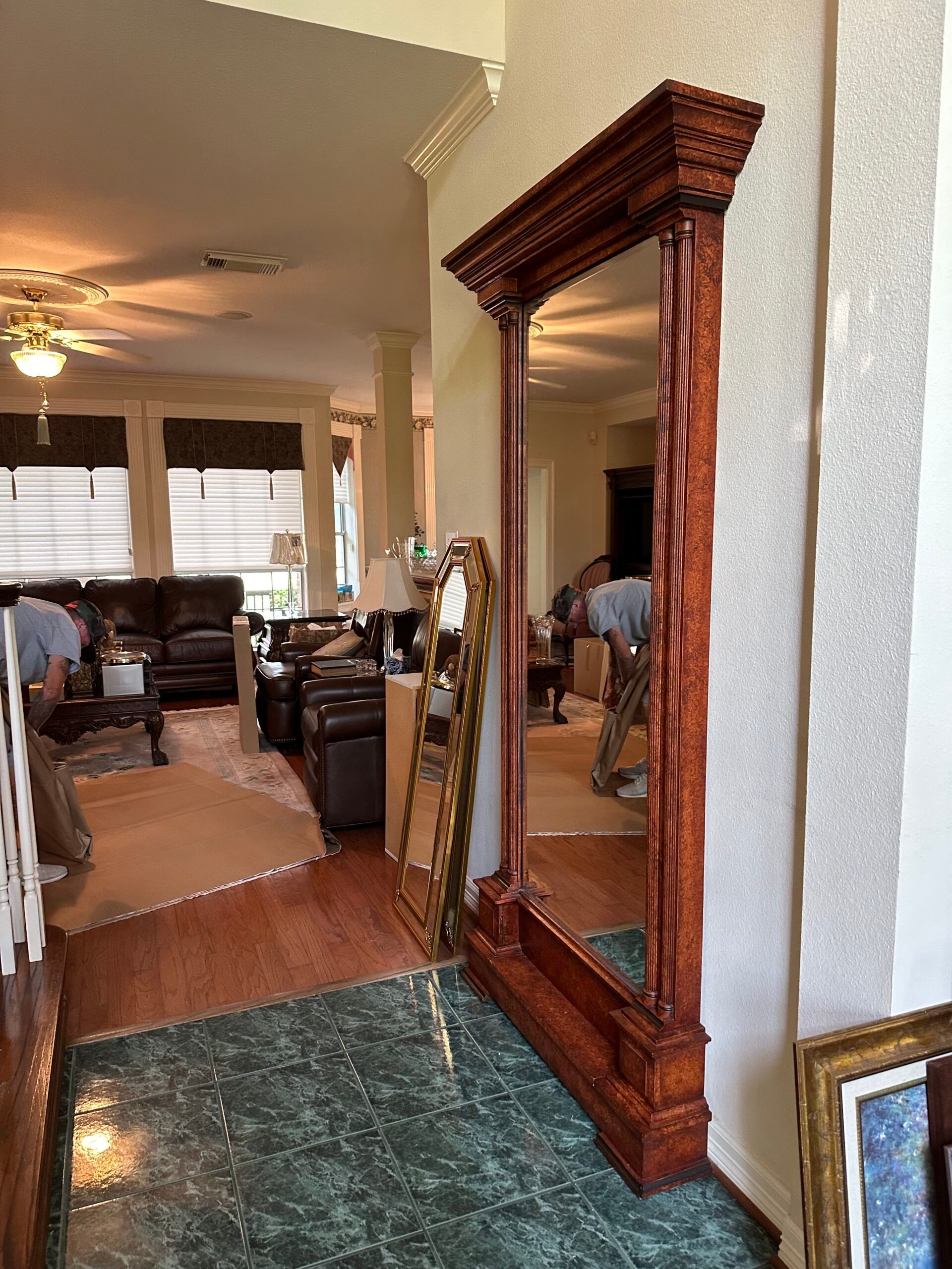 A full length mirror is in the middle of a living room