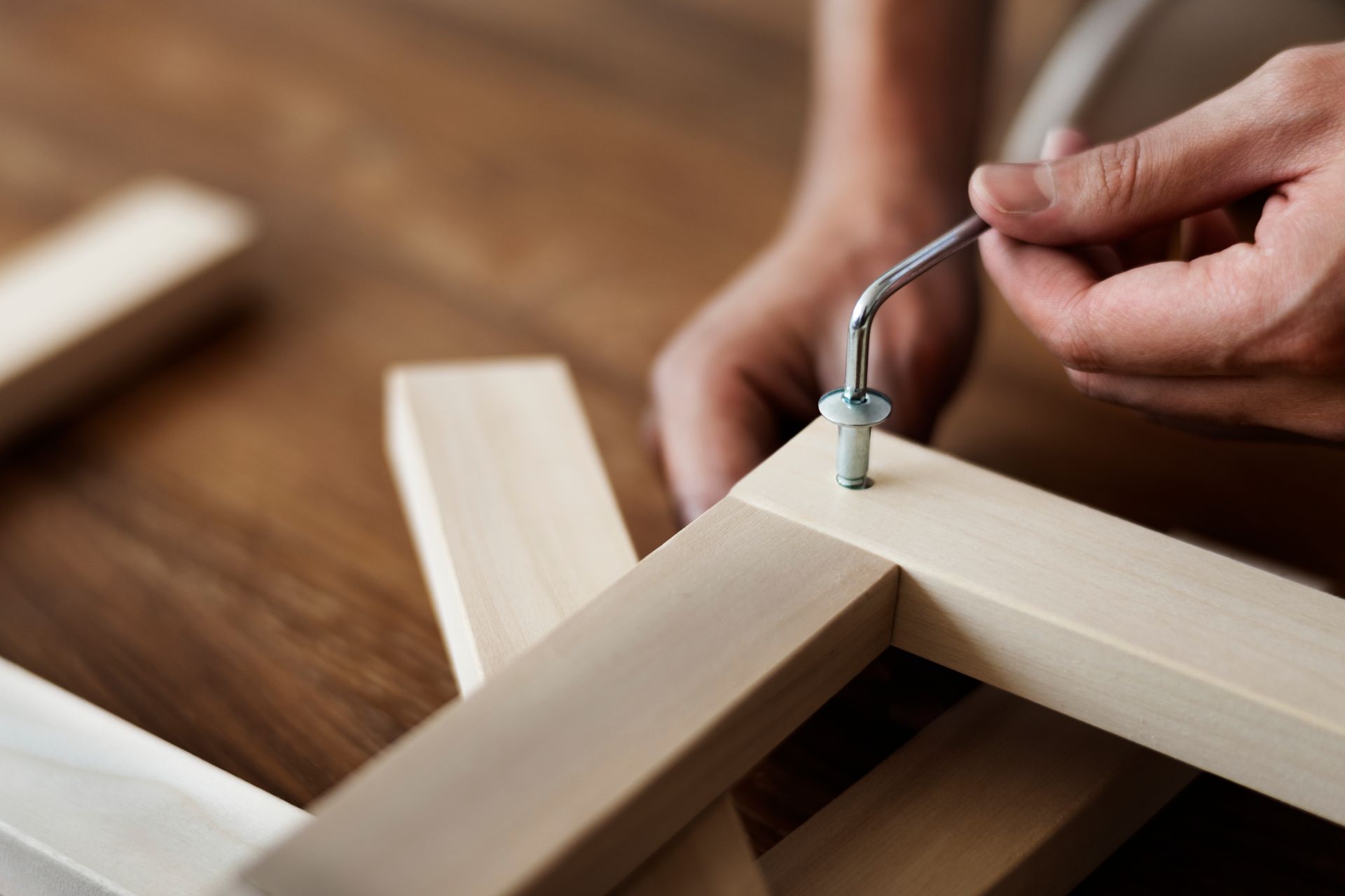 A person is screwing a screw into a piece of wood.